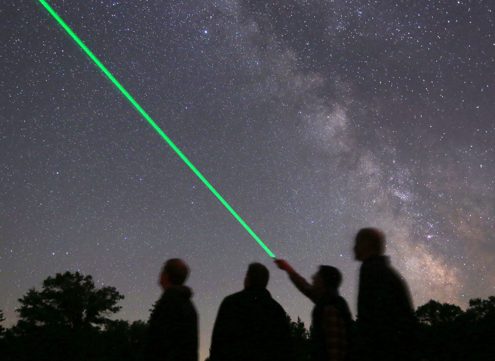 Science enthusiasts aiming green lasers at the sky or space.